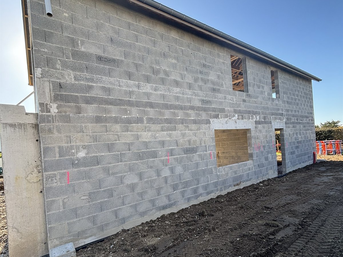 Élévation des murs en parpaing d'une maison neuve