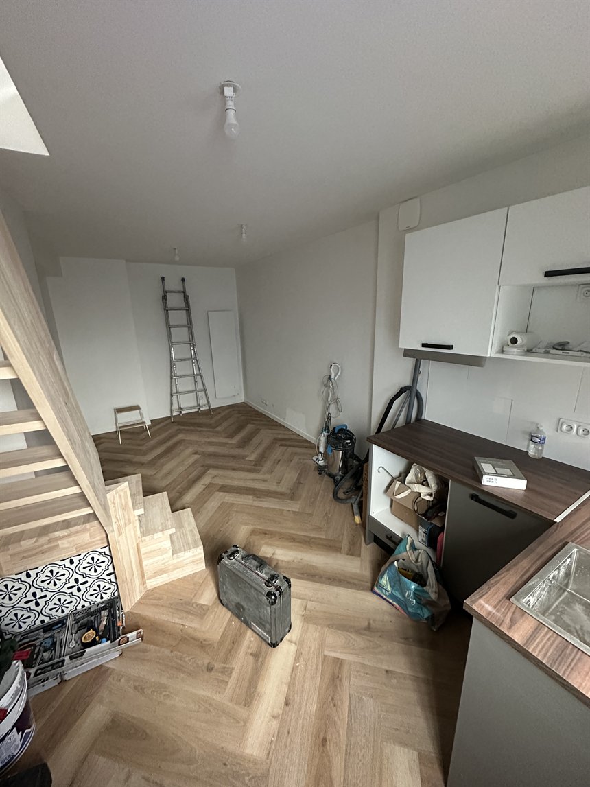 Salon fini avec cuisine et parquet après travaux
